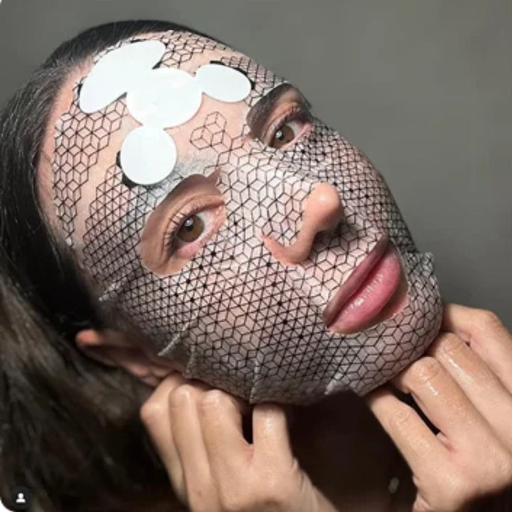 Woman wearing Celexo Galvanic Microcurrent Mask with graphene hexagon pattern and attached ultra-thin battery during facial treatment