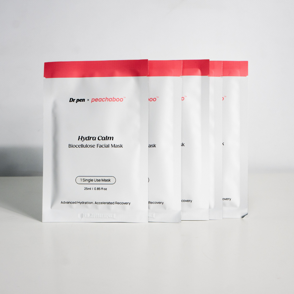 Four Dr. Pen x Peachaboo Hydra Calm Biocellulose Facial Mask sachets standing in a row, each labeled as single-use masks for hydration and recovery.