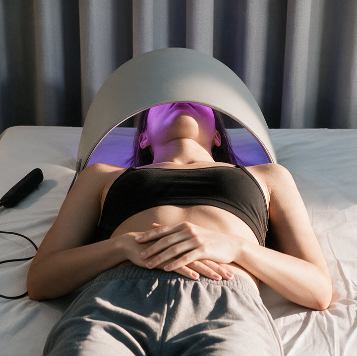 Woman relaxing under the GooMi FlexiGlow Red Light Therapy Panel  during an at-home light therapy session