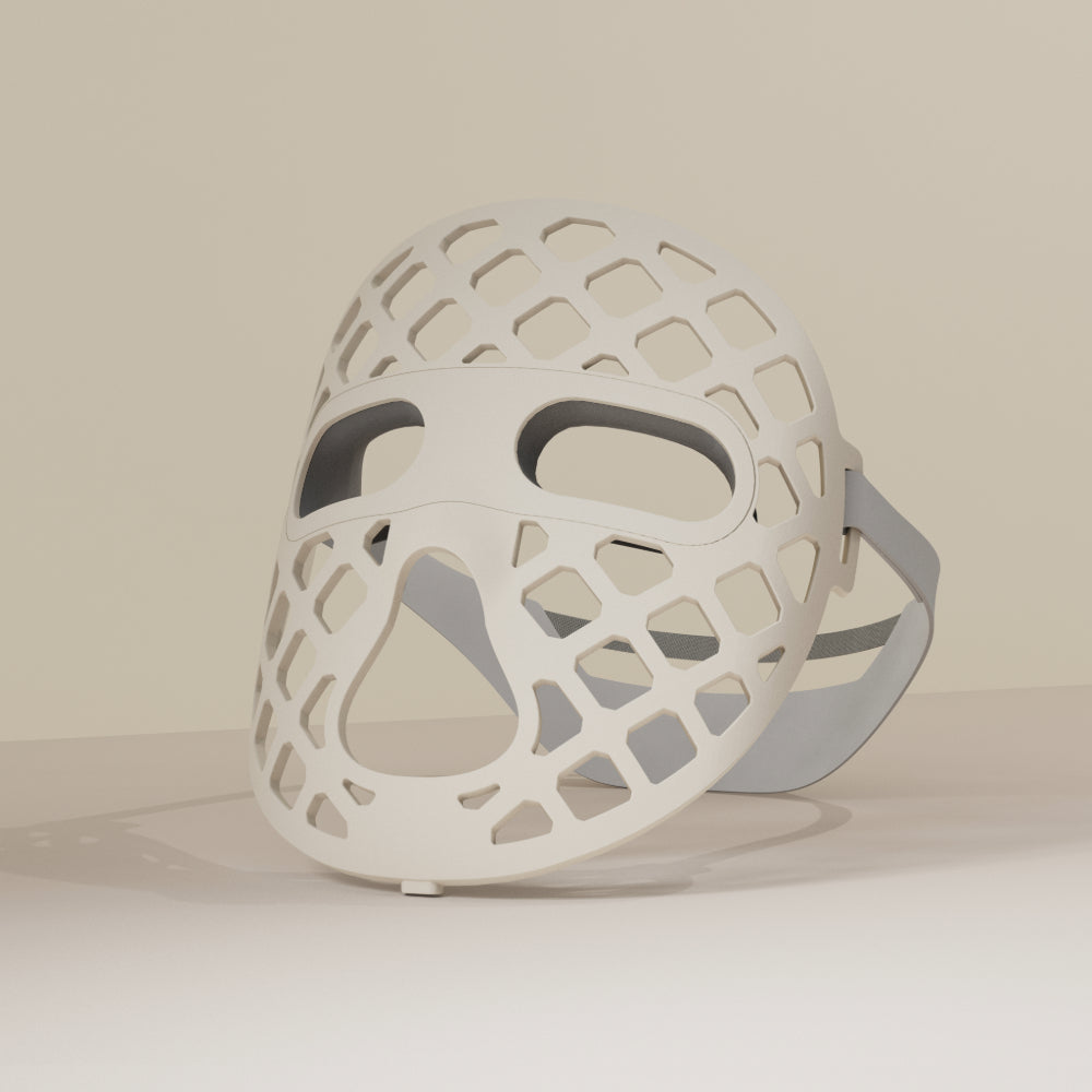 A white mesh-designed mask, the Peachaboo Glo Aurora, featuring LED light therapy technology for skin rejuvenation.