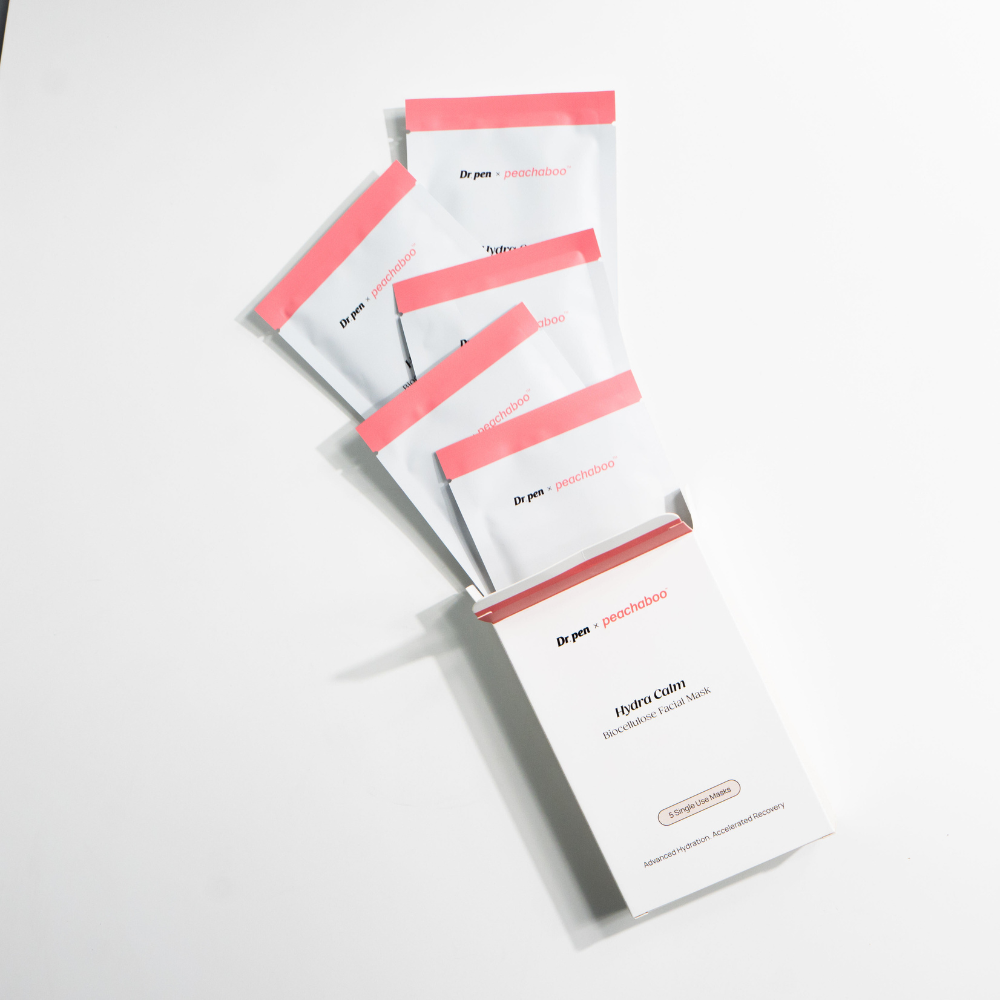 Opened Dr. Pen x Peachaboo Hydra Calm Biocellulose Facial Mask box with five sachets fanned out on a white background, showcasing the complete set.