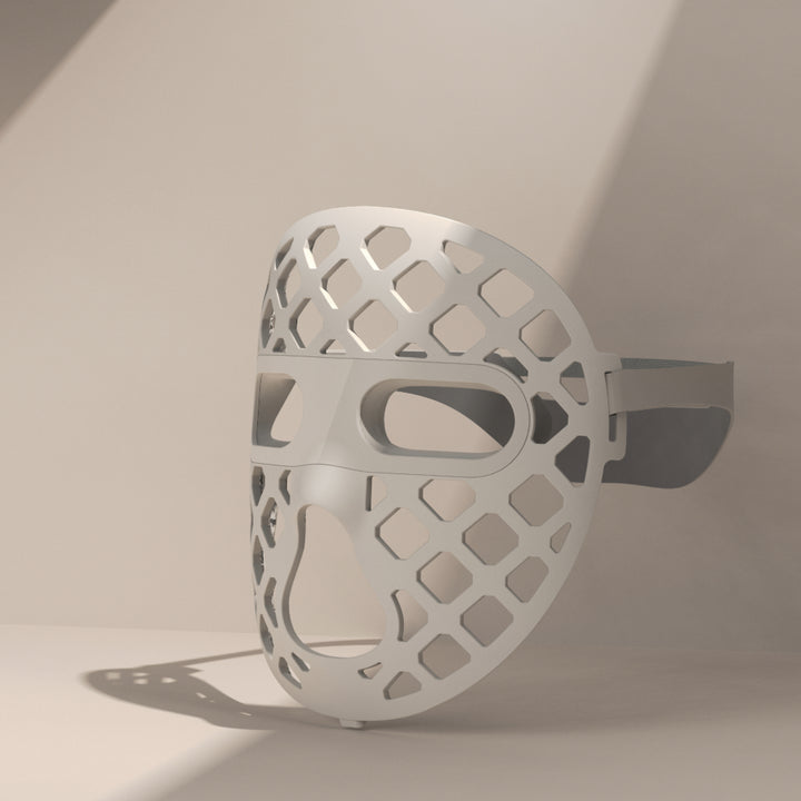 A white mesh-designed mask, the Peachaboo Glo Aurora, featuring LED light therapy technology for skin rejuvenation.