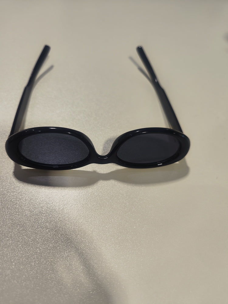 A stylish pair of black sunglasses on a table, intended for eye protection