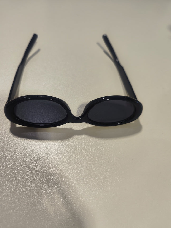 A stylish pair of black sunglasses on a table, intended for eye protection