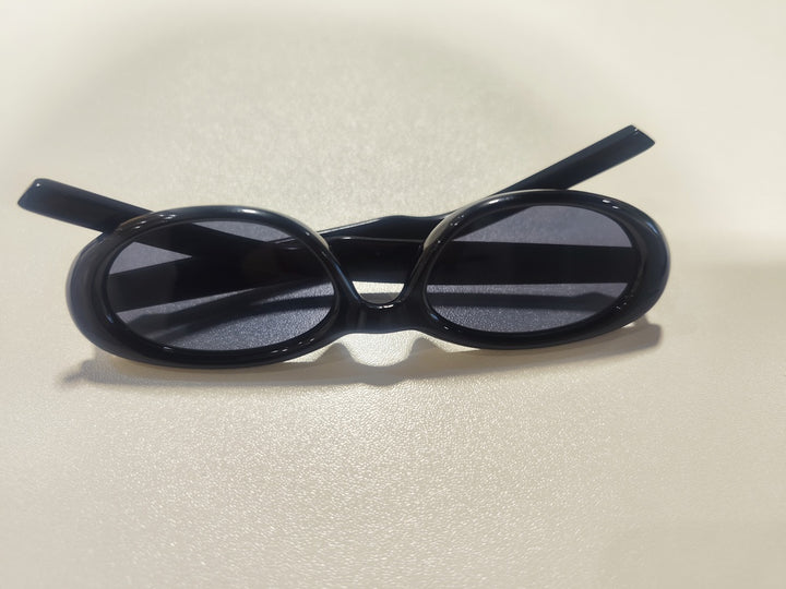 A stylish pair of black sunglasses on a table, intended for eye protection