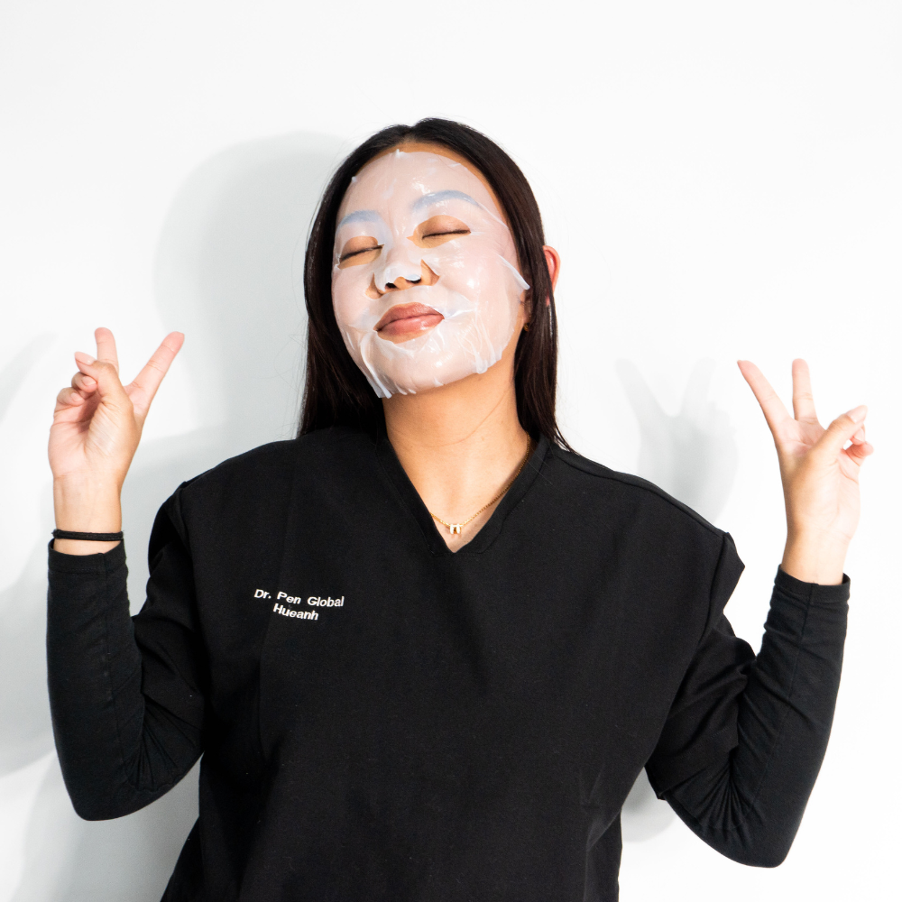 Smiling woman enjoying self-care with Dr. Pen x Peachaboo Hydra Calm Biocellulose Facial Mask, a calming, hydrating mask for radiant, healthy skin.