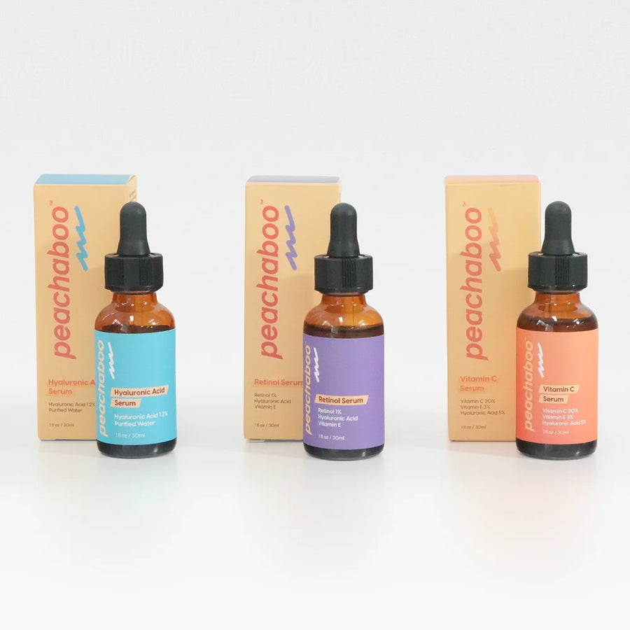 Three peachaboo serums (Peachaboo Hyaluronic Acid Serum, Peachaboo Retinol Serum, Peachaboo Vitamin C Serum) dropper bottles with amber glass, black caps. 