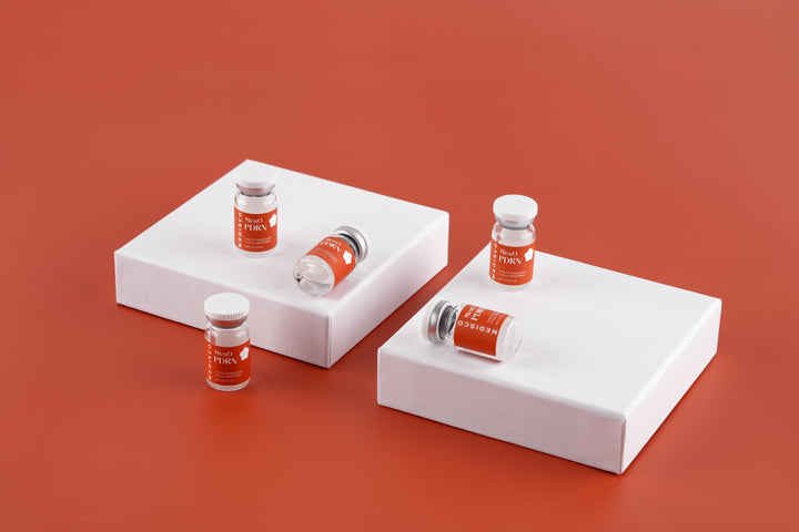 Medisco MesO PDRN Ampoule vials showcased on white blocks against an orange backdrop.